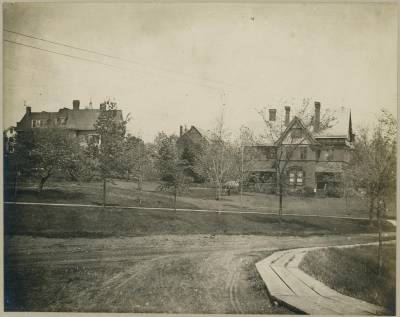 Boardwalk running along the road to the President's House (right) and Smith House (left), ca. 1885. Photo Credit: [[https://www.jstor.org/stable/community.34617039
|Trinity College Archives.]]