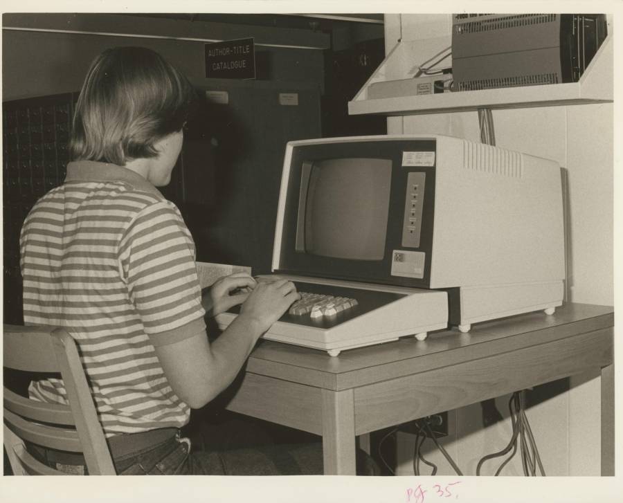 Title: Student at computer in the library (Trinity College, Hartford...